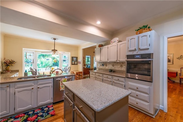 3833 Savannah Sq E, Atlanta, GA 30340 - kitchen featuring appliances with stainless steel finishes, a sink, crown molding, tasteful backsplash, and a ceiling fan
