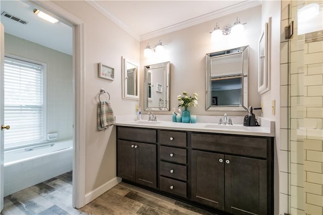 3833 Savannah Sq E, Atlanta, GA 30340 - full bath featuring wood finished floors, ornamental molding, double vanity, tiled tub, and baseboards