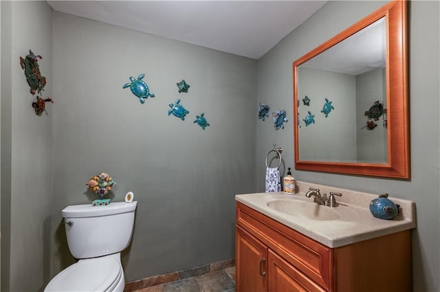 3833 Savannah Sq E, Atlanta, GA 30340 - bathroom featuring vanity, toilet, stone tile floors, and baseboards