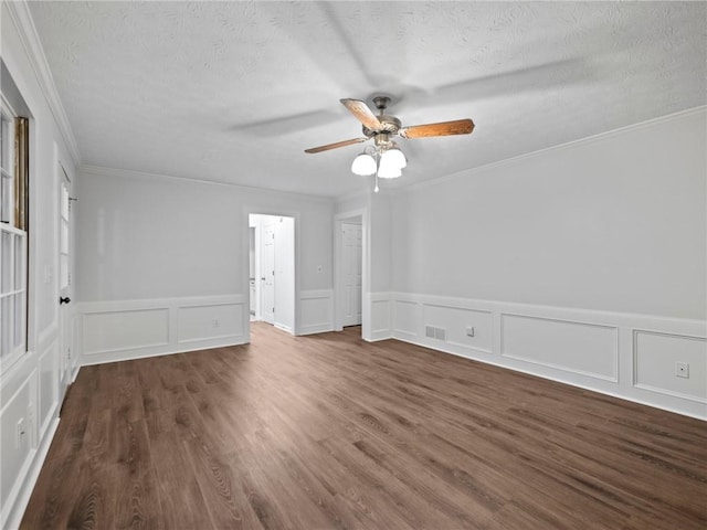 empty room featuring a textured ceiling, dark hardwood / wood-style flooring, ceiling fan, and crown molding