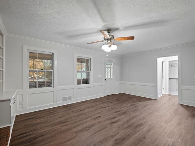 unfurnished room featuring a textured ceiling, dark hardwood / wood-style floors, and crown molding