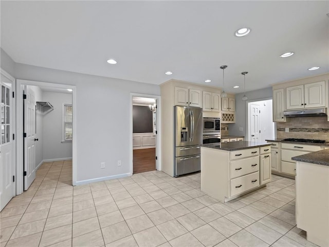 kitchen featuring decorative backsplash, stainless steel appliances, pendant lighting, light tile patterned floors, and cream cabinets