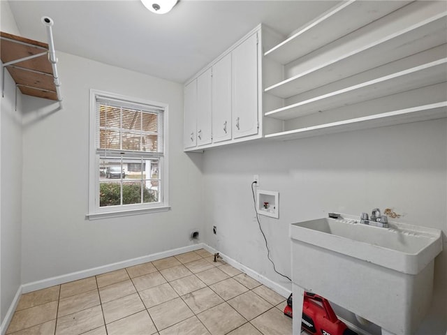 laundry area featuring electric dryer hookup, cabinets, sink, hookup for a washing machine, and light tile patterned floors