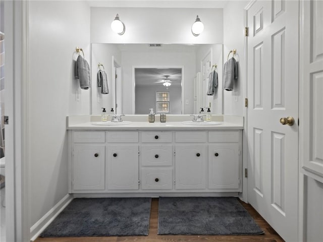 bathroom featuring wood-type flooring, vanity, and toilet