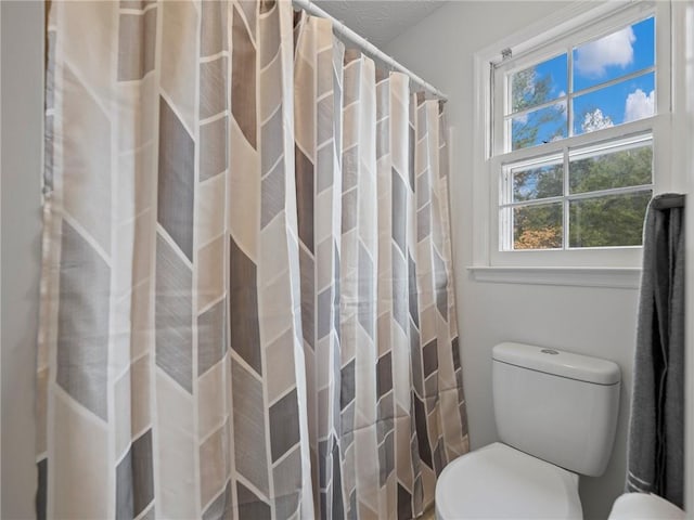 bathroom featuring toilet and walk in shower