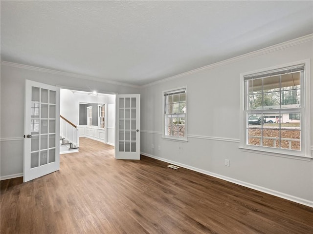 unfurnished room featuring hardwood / wood-style flooring, crown molding, and french doors