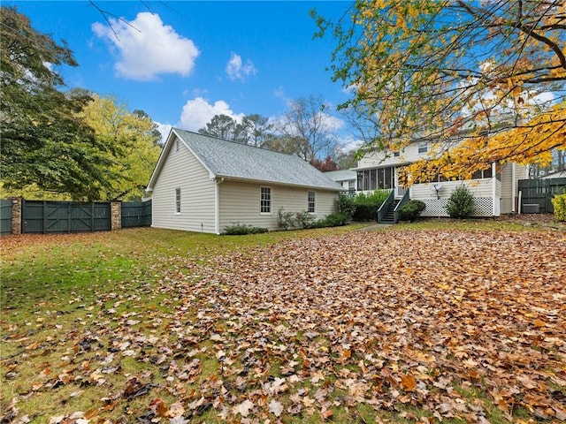 back of house featuring a sunroom and a yard