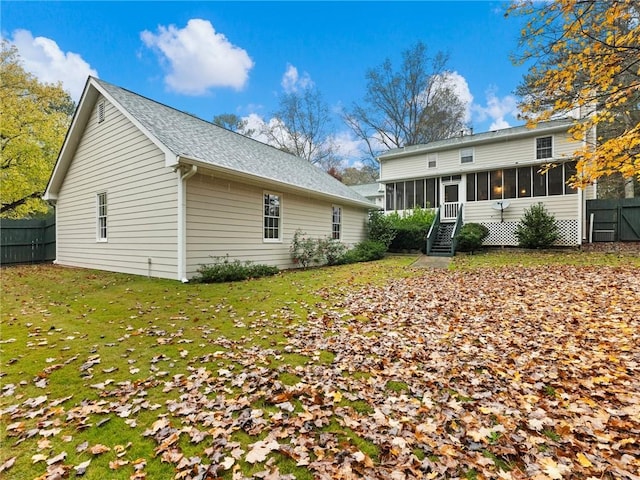 back of house with a yard and a sunroom