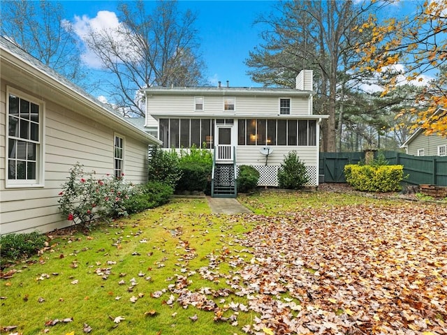 rear view of property with a yard and a sunroom