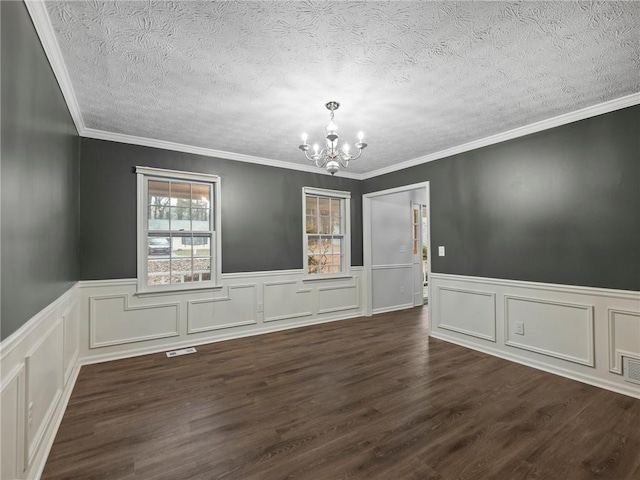 spare room with crown molding, dark hardwood / wood-style flooring, and a notable chandelier