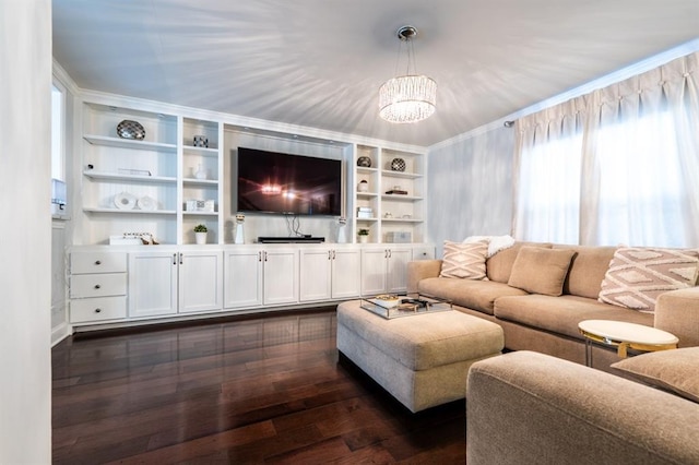 living area featuring ornamental molding, built in shelves, dark wood-style flooring, and a notable chandelier