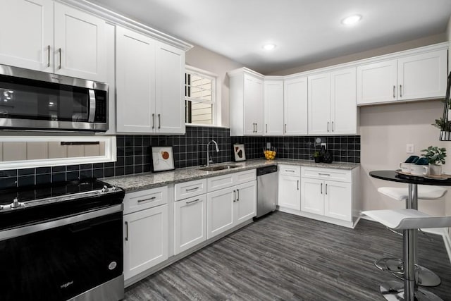 kitchen featuring dark hardwood / wood-style flooring, white cabinets, appliances with stainless steel finishes, and sink