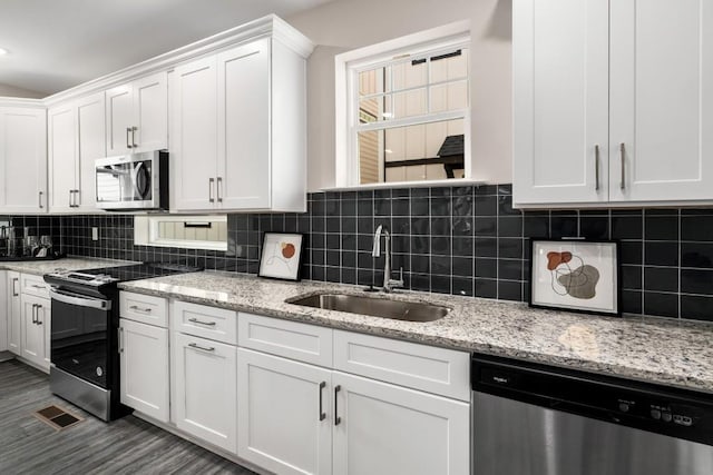 kitchen with dark hardwood / wood-style flooring, stainless steel appliances, white cabinetry, and sink