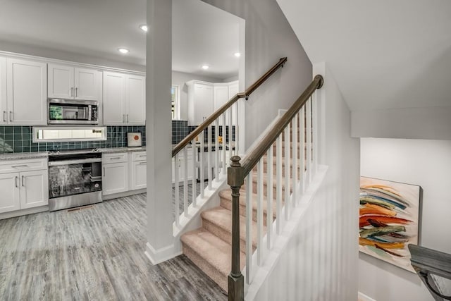 stairs featuring wood-type flooring and vaulted ceiling