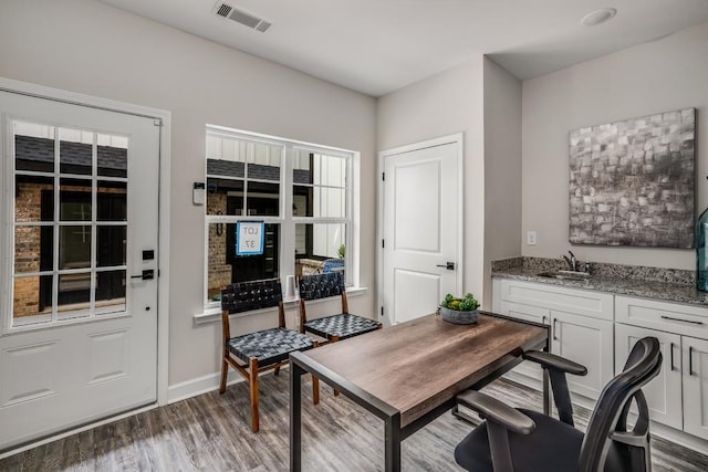 home office with dark wood-type flooring and sink