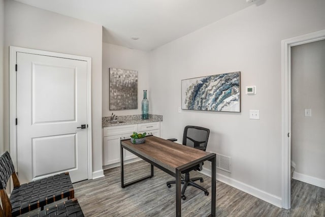 office with dark hardwood / wood-style floors and sink