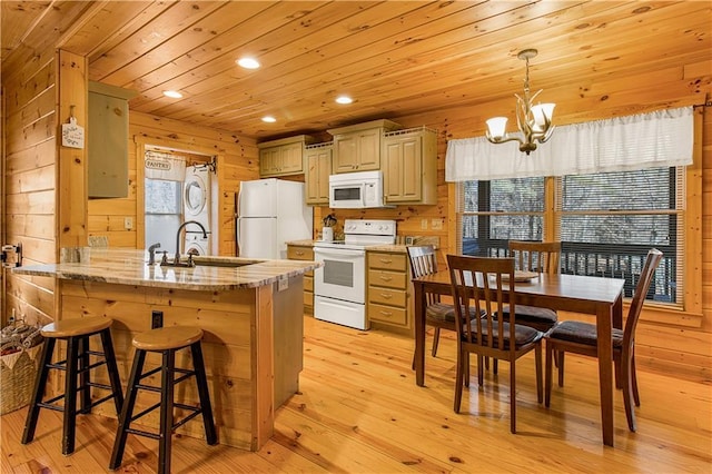 kitchen with pendant lighting, sink, white appliances, wooden walls, and wooden ceiling