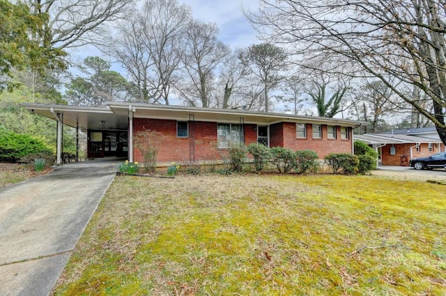 view of front of home featuring brick siding, an attached carport, concrete driveway, and a front yard