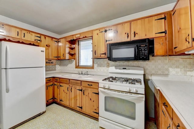 kitchen with white appliances, light floors, a sink, light countertops, and tasteful backsplash