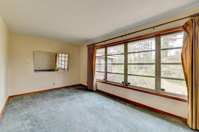 unfurnished room featuring carpet flooring, baseboards, and a wealth of natural light