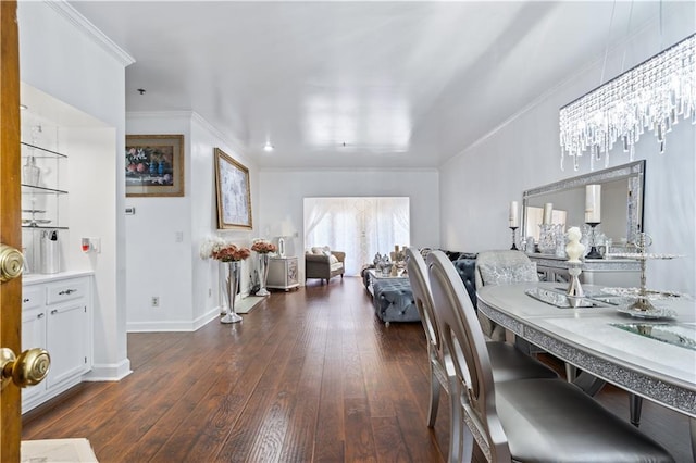 dining area with dark hardwood / wood-style floors, an inviting chandelier, and crown molding