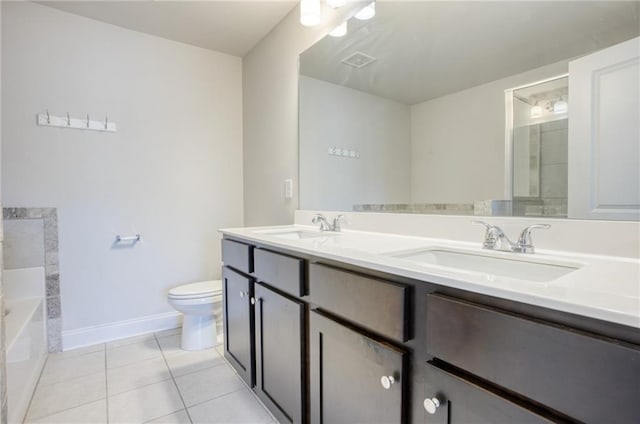 bathroom featuring tile patterned flooring, vanity, a bathtub, and toilet