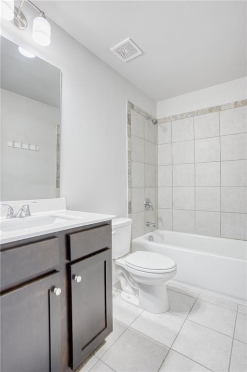 full bathroom featuring tile patterned flooring, tiled shower / bath combo, toilet, and vanity