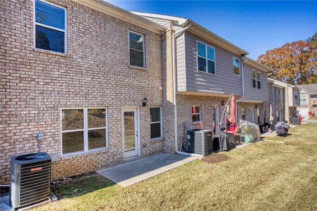 back of house with a lawn, a patio area, and central air condition unit