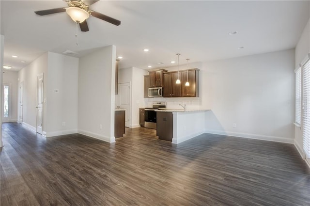 unfurnished living room featuring dark hardwood / wood-style floors, ceiling fan, a healthy amount of sunlight, and sink