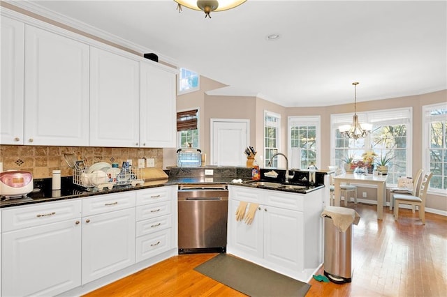 kitchen with hanging light fixtures, white cabinetry, sink, and stainless steel dishwasher