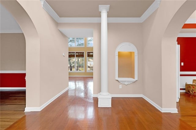 interior space with crown molding, wood-type flooring, and ornate columns