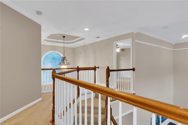 hall with ornamental molding, light carpet, and an inviting chandelier