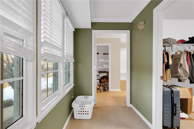 hallway with crown molding and light carpet