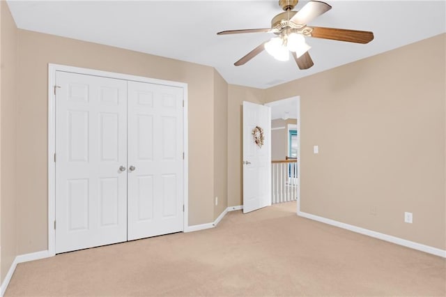 unfurnished bedroom featuring light carpet, ceiling fan, and a closet