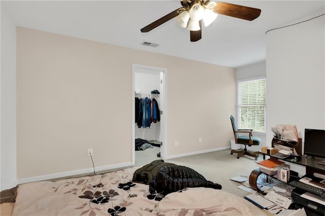 carpeted bedroom featuring a spacious closet, ceiling fan, and a closet