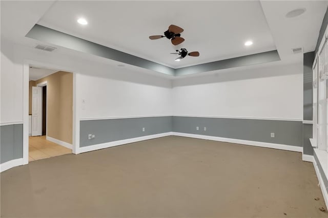 empty room with a raised ceiling and ceiling fan