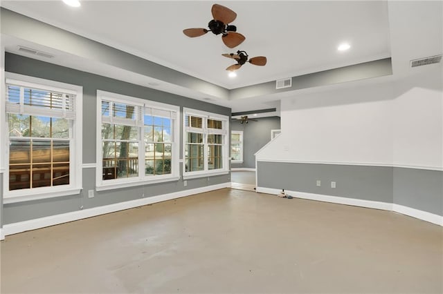 interior space with a tray ceiling, concrete flooring, and ceiling fan