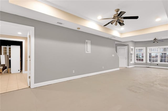 unfurnished living room featuring ceiling fan and a raised ceiling