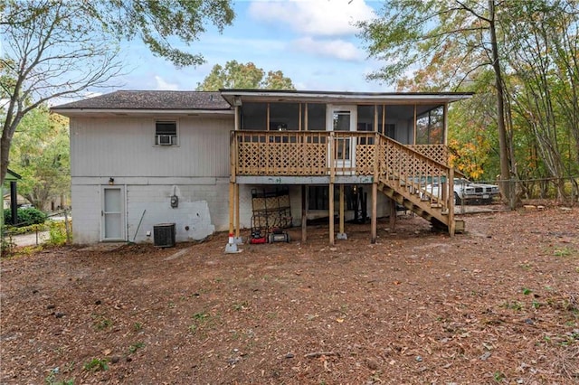 rear view of house featuring a sunroom and a deck