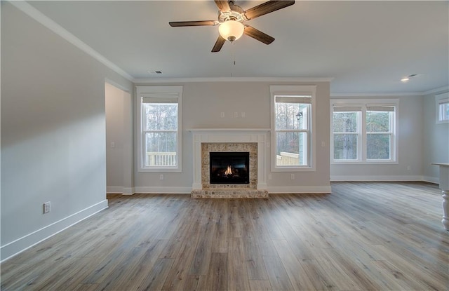 unfurnished living room with ceiling fan, light wood-type flooring, and crown molding