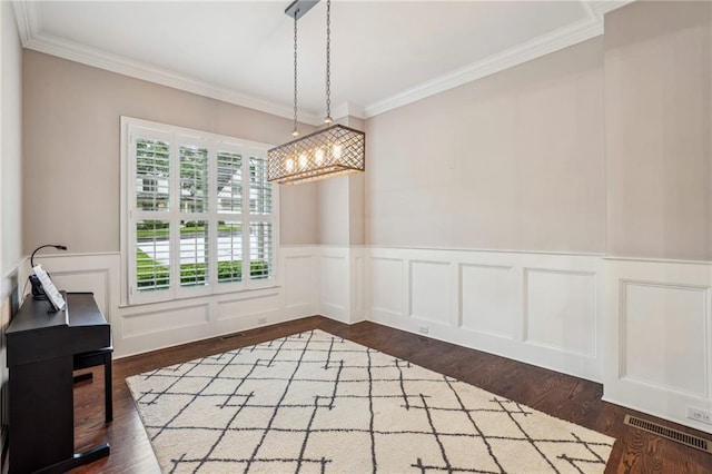 2585 Drew Valley Rd NE, Brookhaven, GA 30319 - unfurnished dining area with a chandelier, ornamental molding, wainscoting, a decorative wall, and dark wood-type flooring