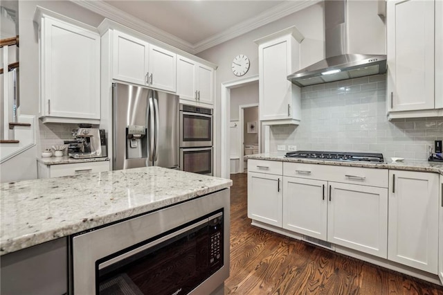 2585 Drew Valley Rd NE, Brookhaven, GA 30319 - kitchen featuring wall chimney exhaust hood, appliances with stainless steel finishes, crown molding, white cabinetry, and dark wood finished floors