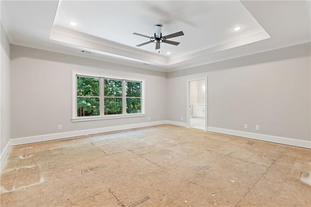 empty room featuring a tray ceiling, ornamental molding, and ceiling fan