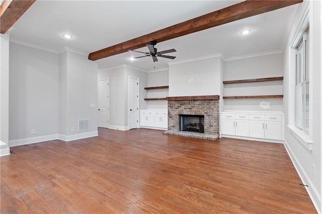 unfurnished living room with ornamental molding, wood-type flooring, and beam ceiling