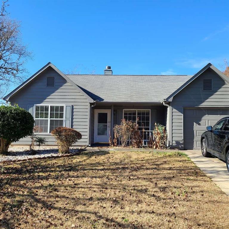 ranch-style house with a garage and a front lawn