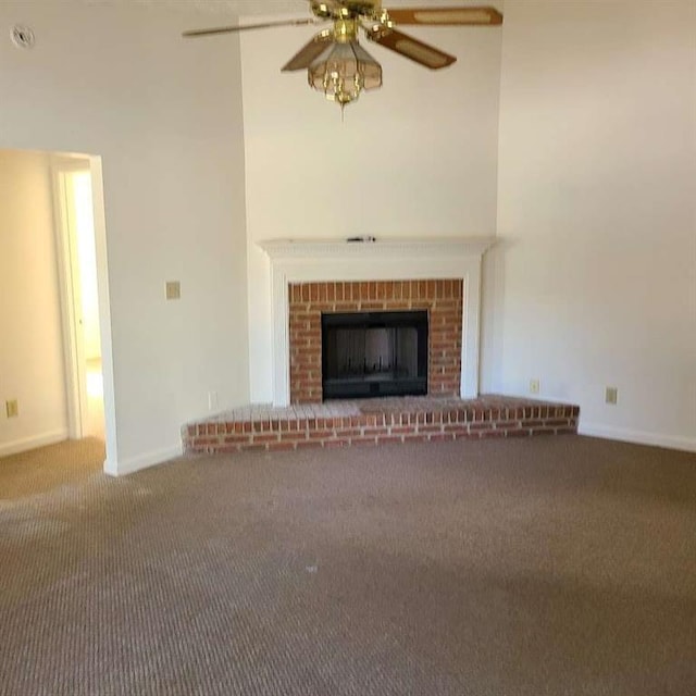 unfurnished living room featuring carpet, ceiling fan, and a fireplace