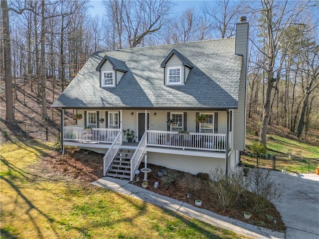 view of front of property with covered porch, a shingled roof, a front lawn, and fence