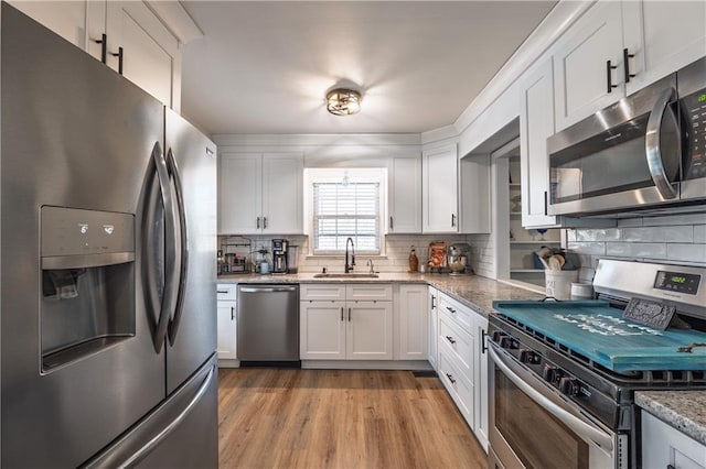 kitchen with a sink, appliances with stainless steel finishes, and white cabinets