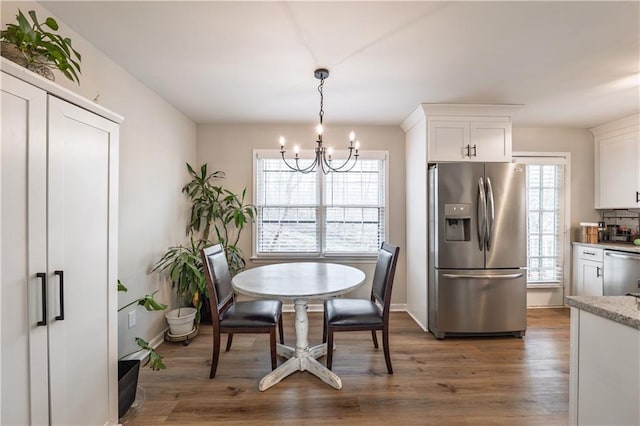 dining room with wood finished floors, baseboards, and a chandelier