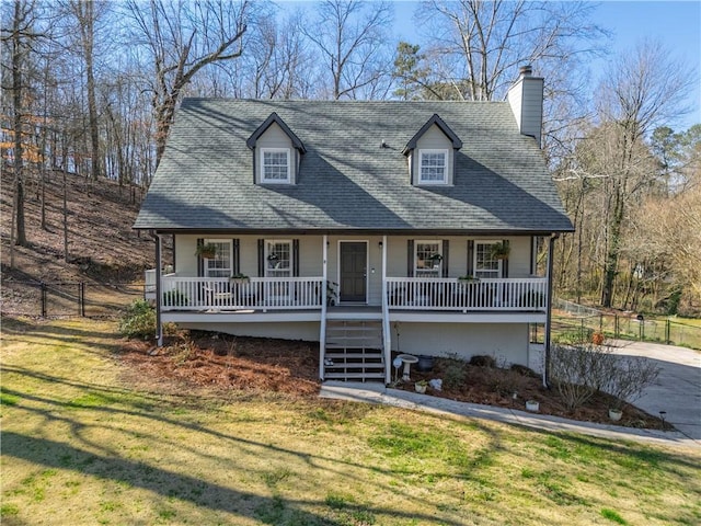 view of front facade with a front yard, stairway, fence, covered porch, and a shingled roof